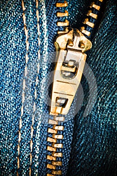 Close up of a zipper over blue denim