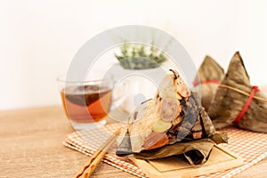 Close up Zongzi or rice dumpling on the wooden table with Chinese tea in Dragon Boat Festival, Asian traditional food