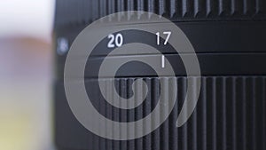 Close up of zoom scale on black digital camera lens. Action. Close up of professional photographing equipment details on