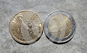 Close upof a Dollar coin and a two Euro