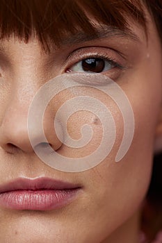 close vertical photo of a young woman with clean, well-groomed skin looking into the camera