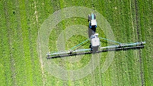 Close vertical view tractor trailed sprayer drives on field