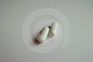 Close view of 2 white caplets of kelp dietary supplement