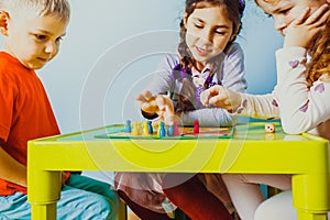 Close view of children faces around table with board game