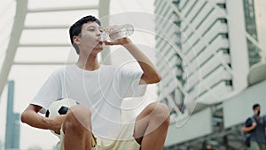 Close View of the Asian Teenage Guy Outside Drinking Water After Training. Athletic Young Football Player with Drink for