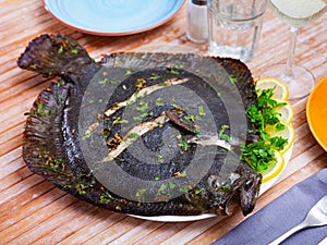 Close view of baked flounder on plate with parsley