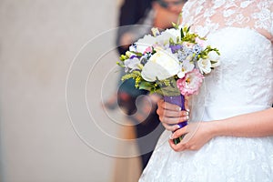 Close view of beautiful colorful wedding bouquet in a hand of a bride