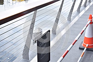 Close view of a bridge railing with orange and white cones