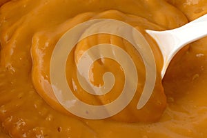 Close view of butterscotch pudding with a spoon