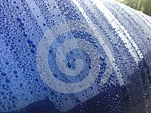 Close view on car paint polished with water drops beading