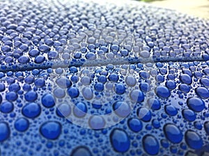 Close view on car paint polished with water drops beading