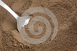 Close view of carob powder on a spoon