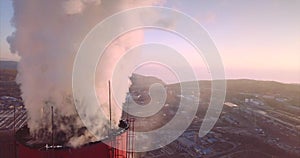 Close view of Central Heating and Power Plant chimney top with steam. Dawning