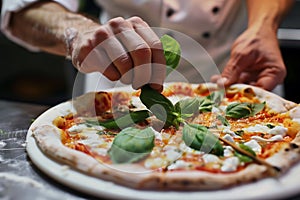 close view of a chef decorating a gourmet pizza with basil leaves