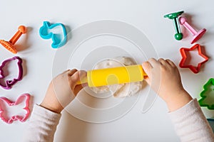 Close view of child`s hands playing with homemade playdough.