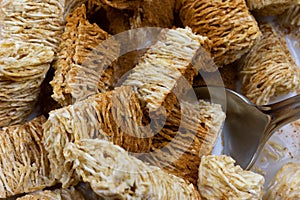 Close view of cinnamon on wheat cereal with milk and a spoon