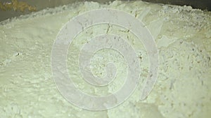 Close view of dough for mixing in a bowl for baking bakery products in a factory