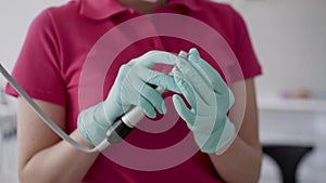 Close view of female dentist in gloves preparing the dental tool