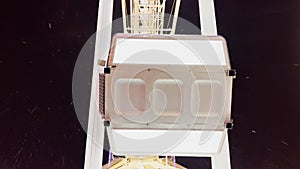 Close view of Ferris wheel cabins move over night sky