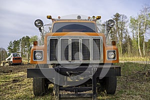 Close view of the front of an orange truck at construction site