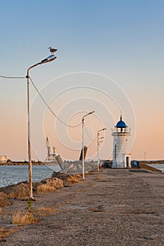 Close view of the Genoese lighthouse with a blue roof, from the pier
