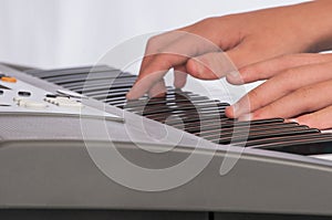 Close view of hands on electric keyboard