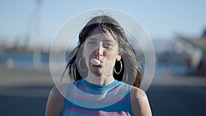 Close view of happy dark-haired girl trying to blow chewing gum bubble