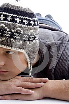 Close view of laying young man wearing winter hat