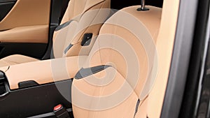 Close view of leather interior of luxury car, beige. Comfortable perforated seats in business sedan for comfortable ride
