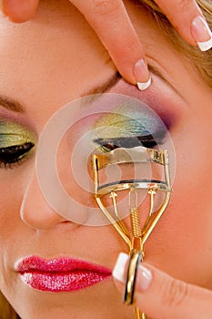 Close view of model curling her eyelashes