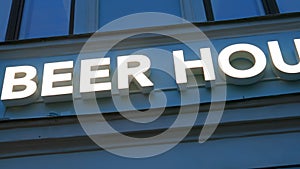 Close view: Modern BEER HOUSE illuminated sign on a pub's facade