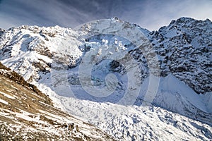 Close view of Mount Cook`s Caroline face from Ball Pass trek. Massive glacier, rocks, snow and avalanches
