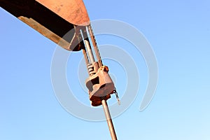 Old rusty oil derrick in sunlight with blue sky