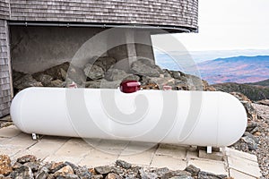 Close view of a propane tank near a mountaintop building