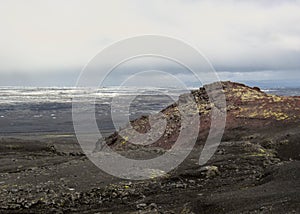 Red volcanic stones, moss and melting glacier on the background, Kverkfjoll, Highlands of Iceland, Europe