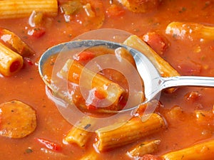 Close view of rigatoni pasta and sausage with a spoon side view