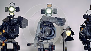 A close view on video cameras lenses and mikes.
