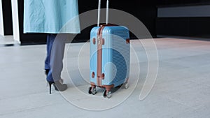 Close view of young woman with suitcase in hands walking through city in autumn spbi.