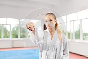 Close of woman fist throwing punch against big window at fight class.