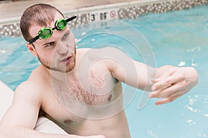 Close of young manstanding in pool and talking.