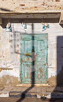 Closed abandoned wooden weathered door and shabby old grunge wall