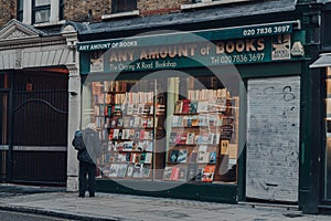 Closed Any Amount of Books bookshop in Covent Garden, London, UK, man looking at the retail display