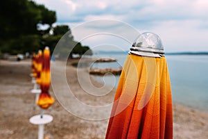 Closed beach parasol at empty seaside coast in Crikvenica, Croatia