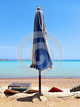 Closed beach umbrella and turquoise waters of the Red Sea in the Sinai Peninsula. Chill out and relaxation