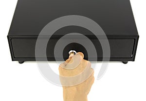 Closed black cash drawer or cashbox and hand with key in lock, top view white background
