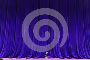 Closed blue curtain background spotlight beam illuminated. Theatrical drapes