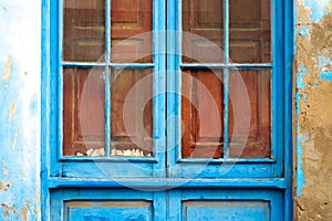 Closed blue window in an old grungy home.