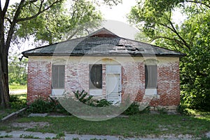 Closed boarded overgrown abandoned rural town building