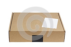 Closed brown cardboard box with blank white label. Box for parcel, delivery or packaging isolated on white
