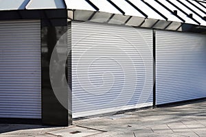 Closed business shop or store front with roller shutters